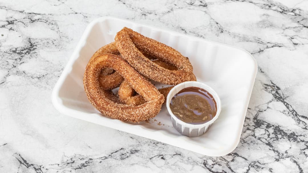 Cinnamon-sugar churro loops with a pot of dipping sauce
