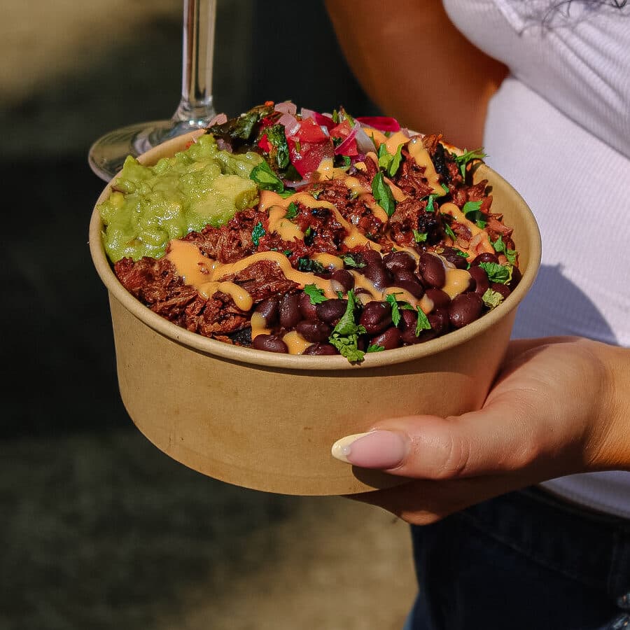 A loaded birria rice bowl with guacamole, black beans and salsa